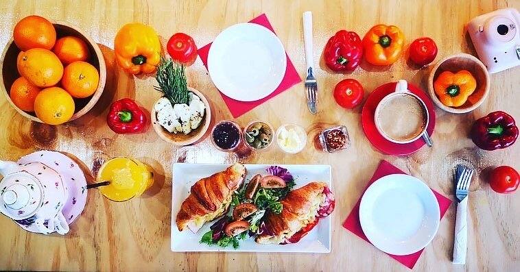 Croissants, salad, orange juice and coffee laid out on a table